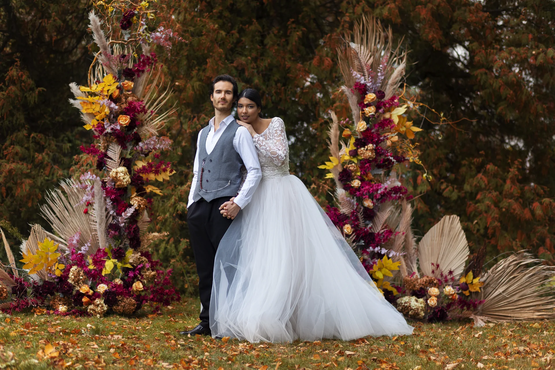 Wedding couple posing among rich autumn flowers